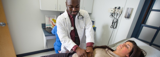 Zoom image: DNP student examining patient.