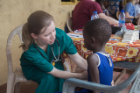 Claire Cowden, an MD/MBA student, performs an exam on a child at Bawaleshie School. Photo: Jordi Owusu