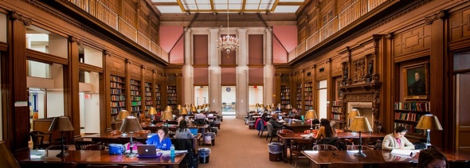 Zoom image: Students studying in a library.