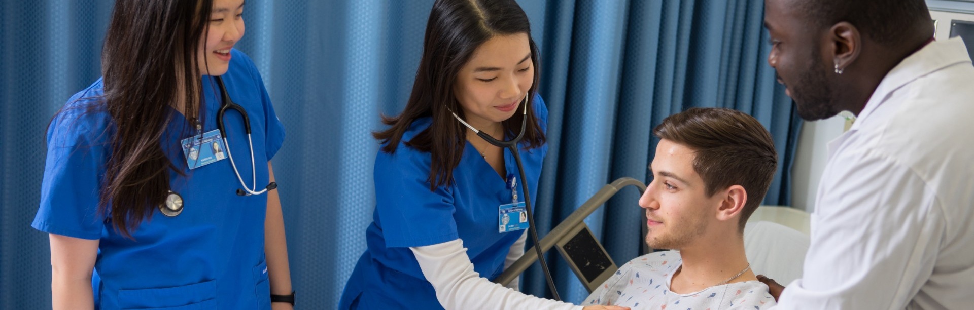 Nursing students examining a patient with a nurse practitioner. 