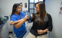 Zoom image: Nursing student taking blood pressure.