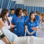 Zoom image: nursing students and faculty in simulation lab.