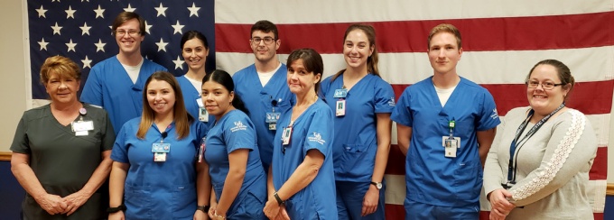 Nursing students and faculty with American flag. 