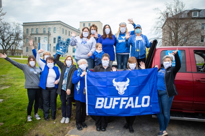 Faculty and staff with masks and UB flags. 
