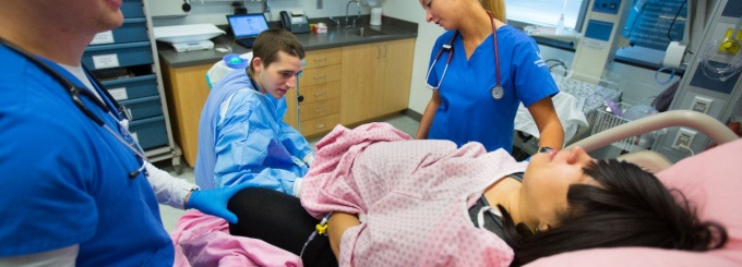 Zoom image: Nursing students participate in a birthing simulation in the Behling Human Simulation Center. 