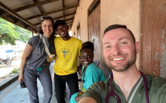 Health care professionals posing for a selfie outside of a medical clinic in Ghana. 